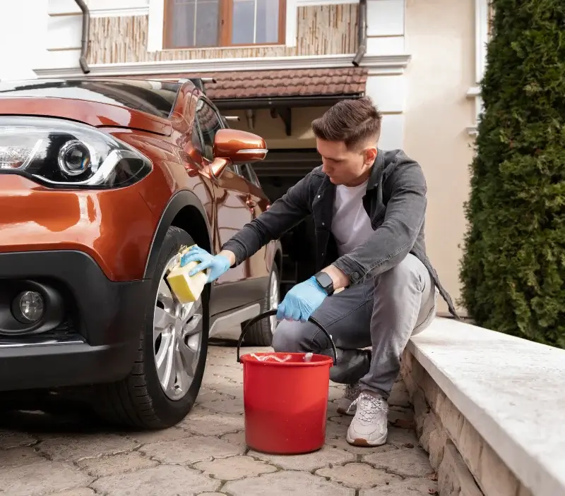 Lavage auto à domicile Les Pineaux : professionnel intervenant sur un véhicule
